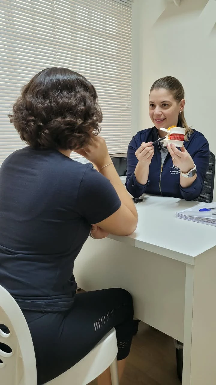 Adriana Decelli explica a coluna vertebral a uma paciente, com um modelo anatômico na mão